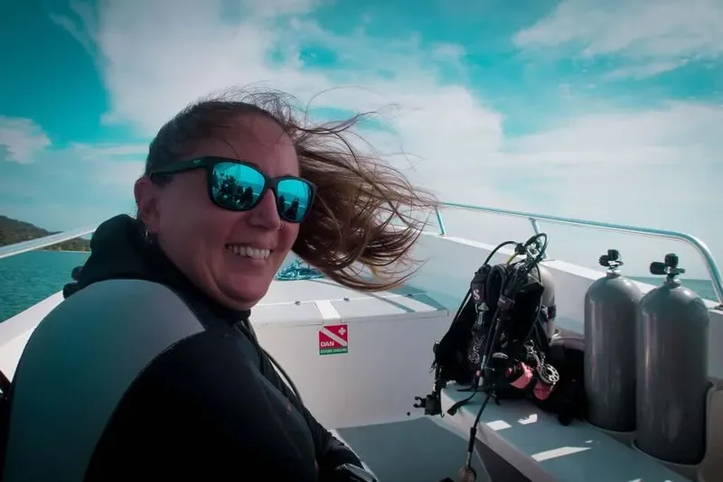 Plongeuse souriante sur un bateau avec équipement de plongée