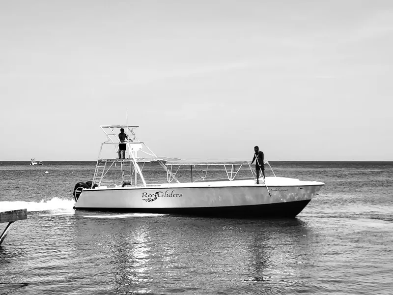 Deux personnes sur un bateau de plongée en mer, ciel clair