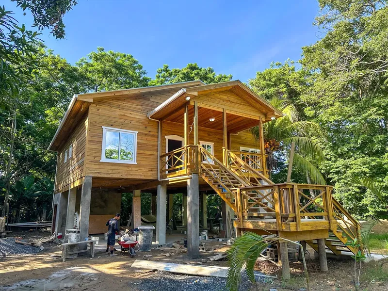 Construction d'une maison en bois sur pilotis dans un environnement tropical