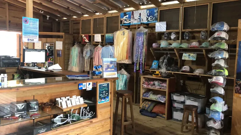 Intérieur d'un centre de plongée avec comptoir, combinaisons et accessoires