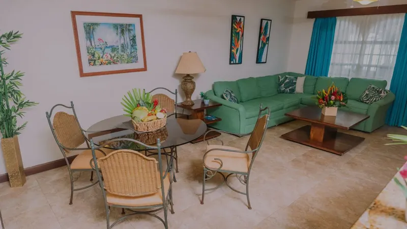 Intérieur lumineux avec coin repas, canapé vert et décoration florale