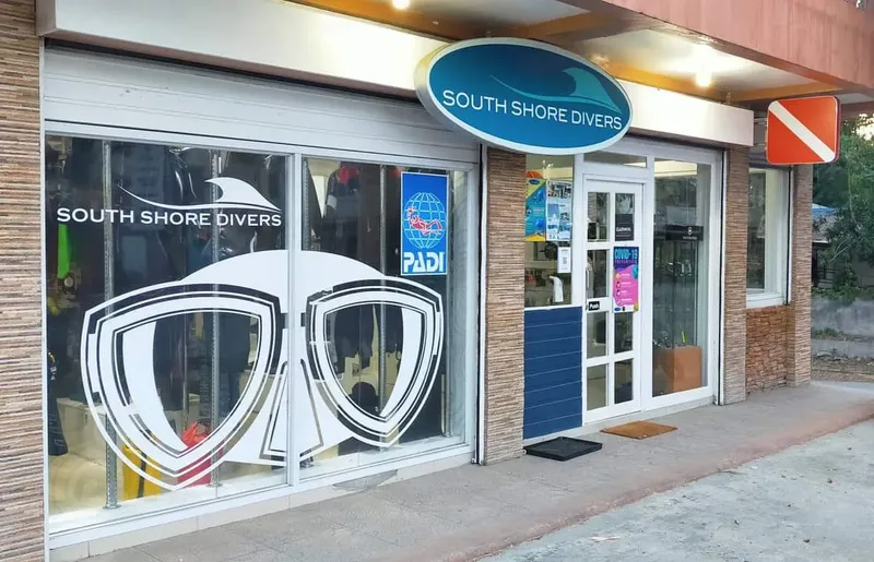 Devanture d'un centre de plongée avec équipement et logos visibles