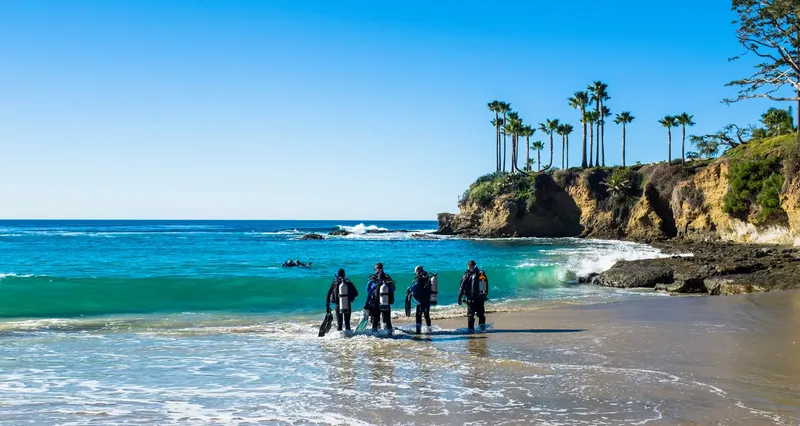 Plongée : groupe de personnes en équipement complet sur une plage