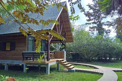 Petite maison en bois sur pilotis avec terrasse et allée en bois