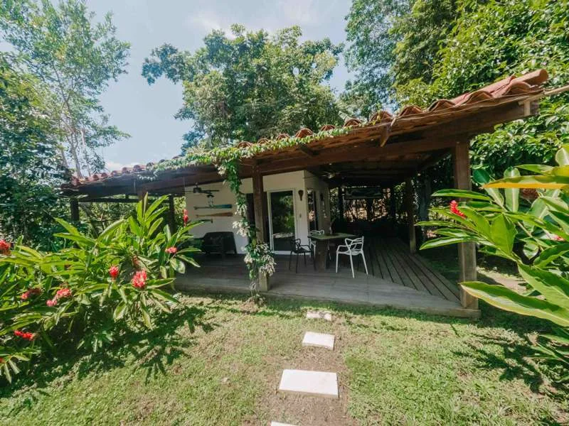 Terrasse ombragée avec mobilier de jardin et végétation tropicale luxuriante