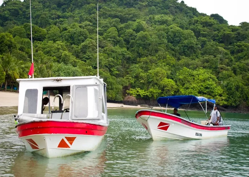 Deux bateaux de plongée amarrés dans une baie tropicale ensoleillée