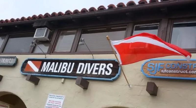 Façade d'un centre de plongée avec enseigne et drapeau plongeur