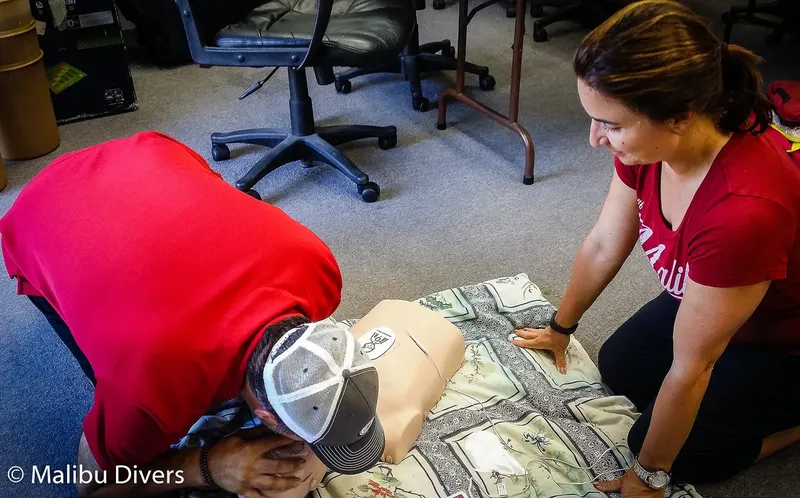 Deux personnes s'entraînent aux gestes de premiers secours sur un mannequin