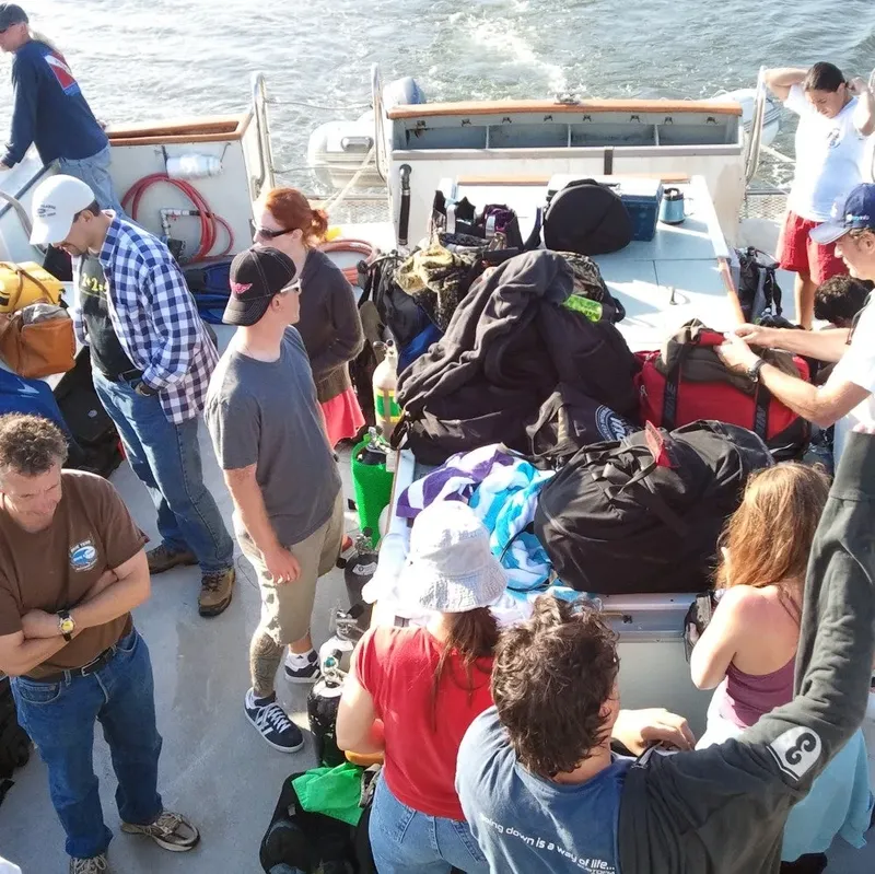 Groupe de plongeurs sur le pont d'un bateau avec équipement