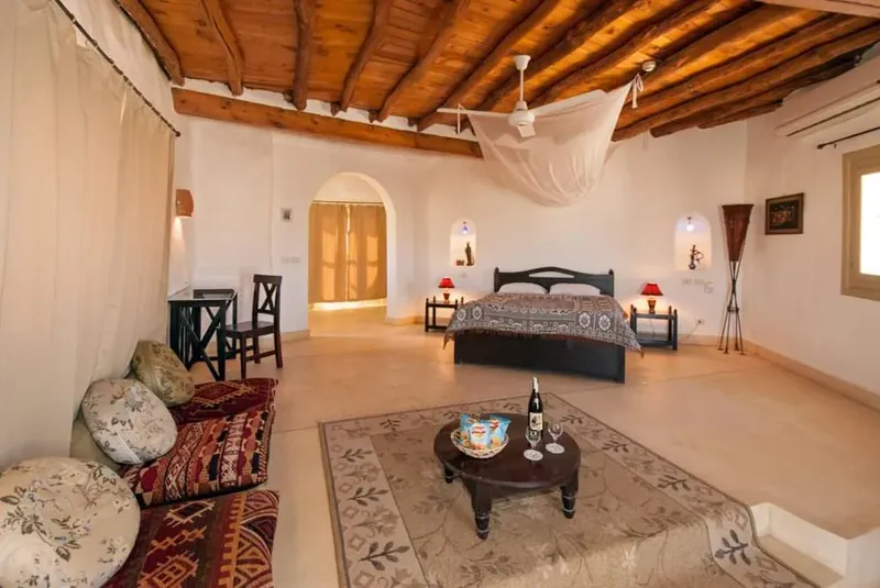 Chambre d'hôtel spacieuse avec lit, canapé, table basse et décoration orientale