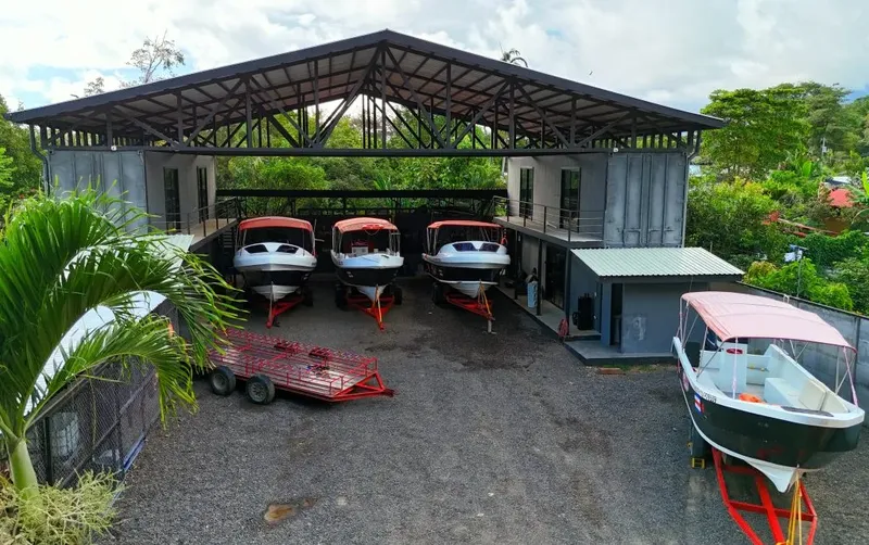 Bateaux de plongée abrités sous une structure métallique et végétation tropicale