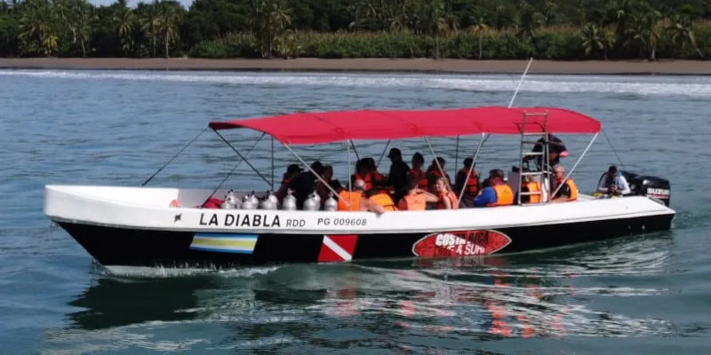 Bateau de plongée rempli de personnes avec des équipements et un auvent rouge