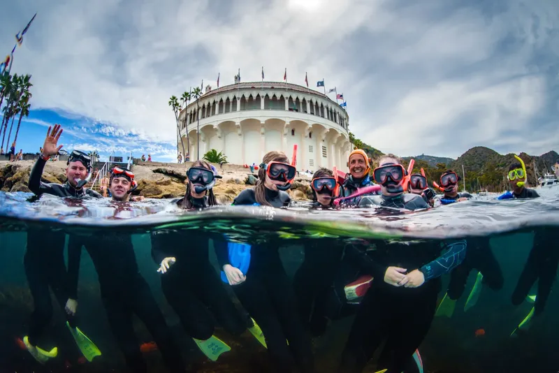 Groupe de plongeurs souriants avec masque et tuba en mer