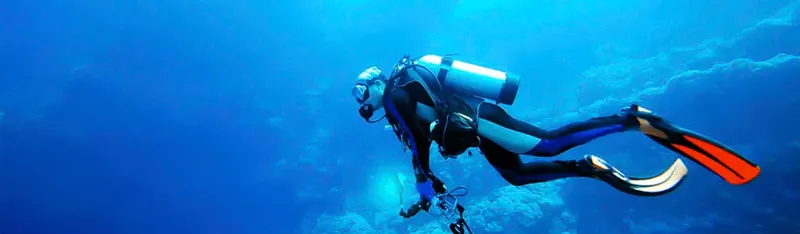 Plongeur en combinaison explore les profondeurs bleues de l'océan