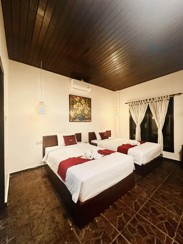 Chambre d'hôtel avec deux lits, décoration florale et éclairage doux