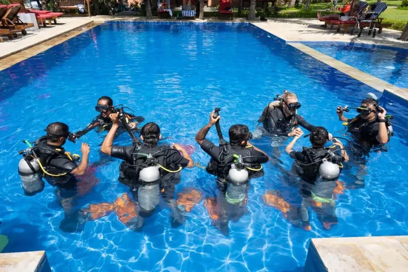 Groupe de plongeurs en formation dans une piscine, équipement complet