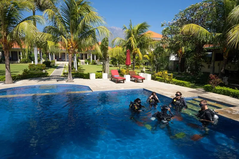 Des plongeurs s'entrainent dans une piscine avec du matériel complet