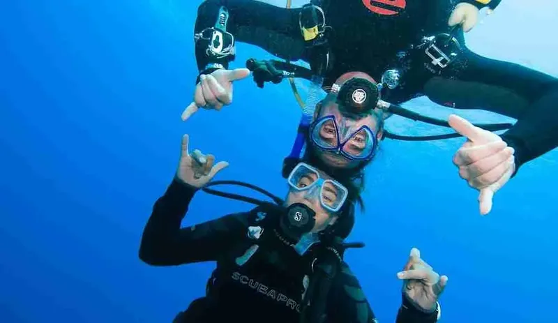 Deux plongeurs souriants font des signes avec leurs mains