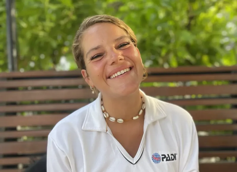 Jeune femme souriante portant un polo avec un logo PADI