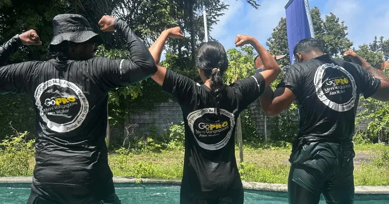 Trois personnes dos à la caméra, les bras levés, souriantes
