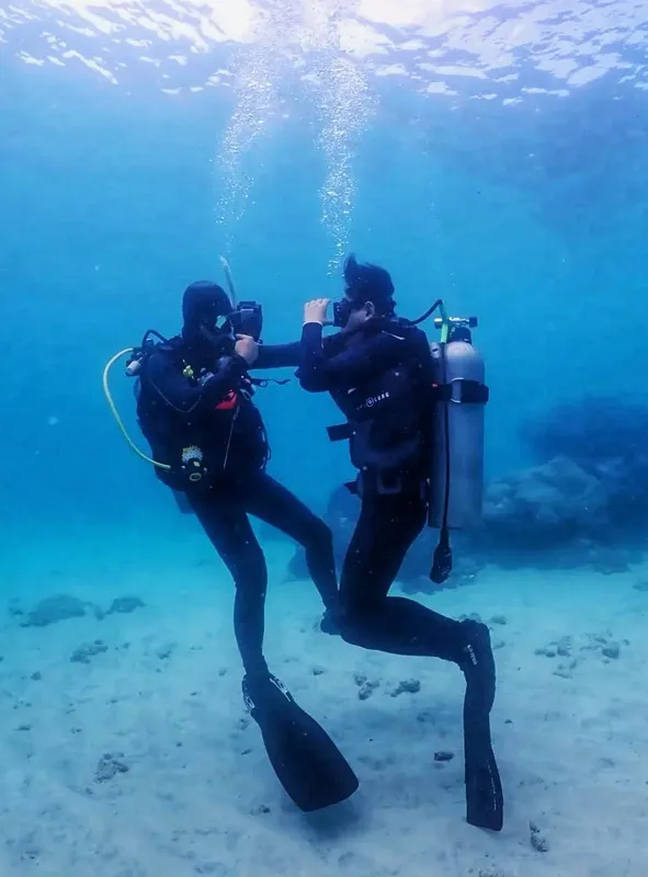 Deux plongeurs s'observent mutuellement dans une eau bleue claire