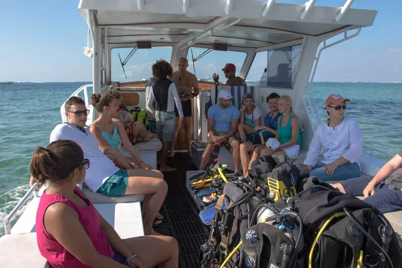 Groupe de plongeurs assis sur un bateau en direction d'un site