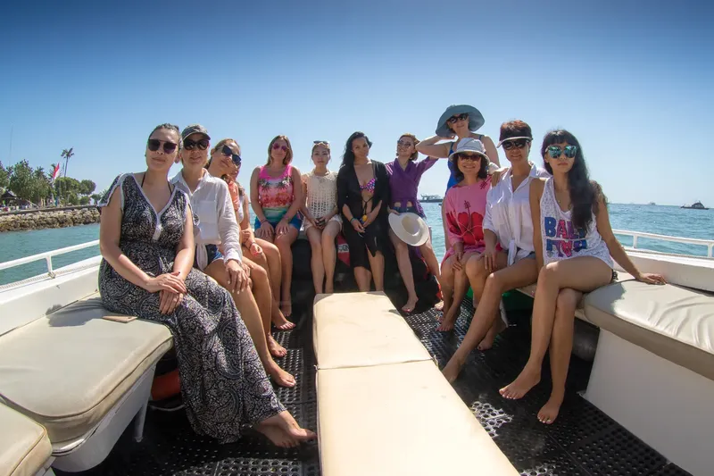 Groupe de personnes souriantes sur un bateau en mer par temps ensoleillé
