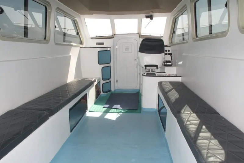Intérieur d'un bateau de plongée avec banquettes et espace central dégagé