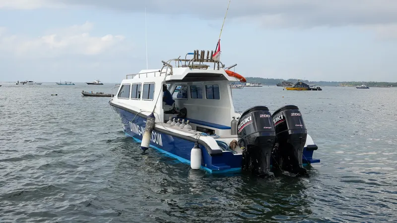 Bateau de plongée blanc et bleu navigue sur une mer calme