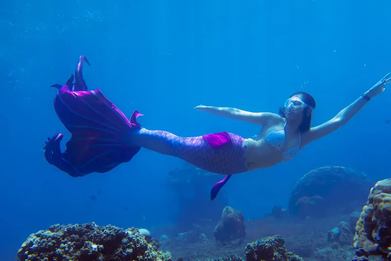Une nageuse en sirène évolue librement dans une eau bleue claire