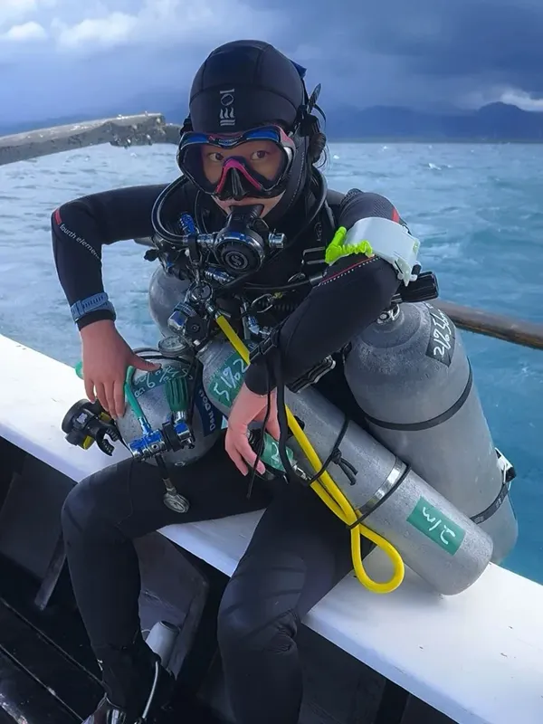 Plongeuse équipée sur un bateau, vérification du matériel avant immersion
