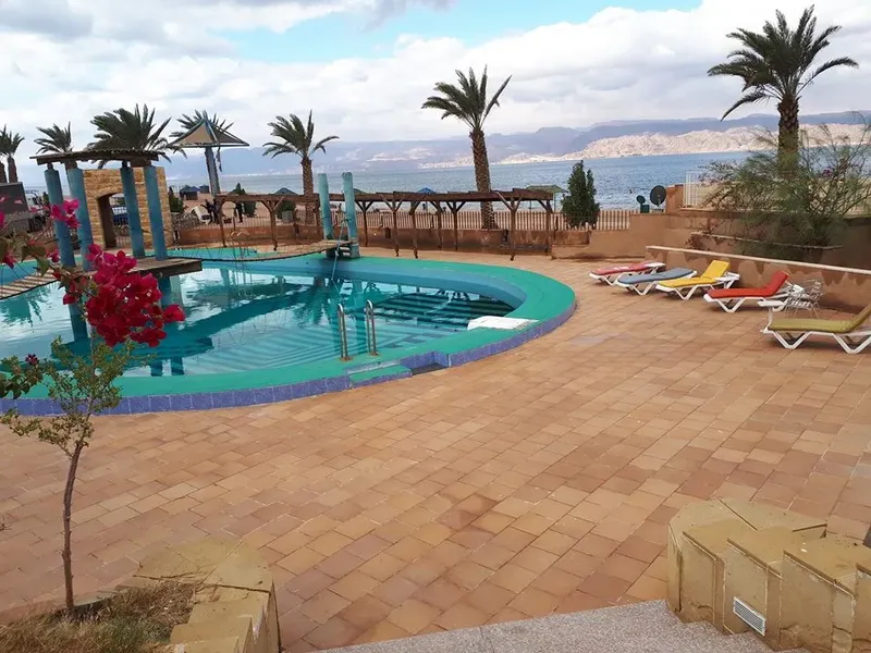 Piscine d'un centre de plongée avec transats et végétation tropicale