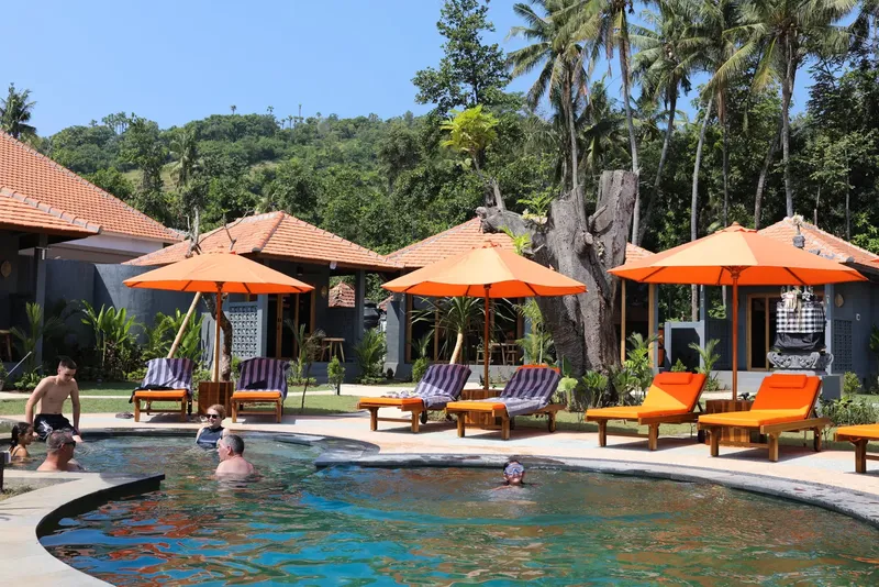 Piscine et transats dans un cadre tropical avec des personnes