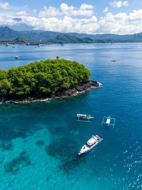 Vue aérienne d'îles tropicales, bateaux en mer, eau turquoise et montagnes