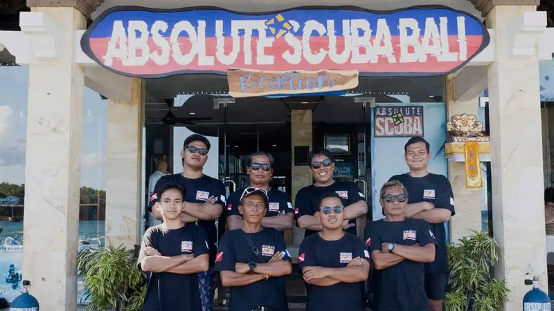 Equipe souriante devant l'entrée d'un centre de plongée à Bali