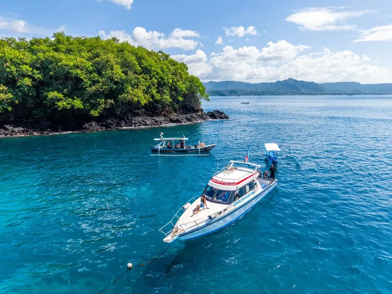 Deux bateaux de plongée naviguent sur une mer bleue turquoise