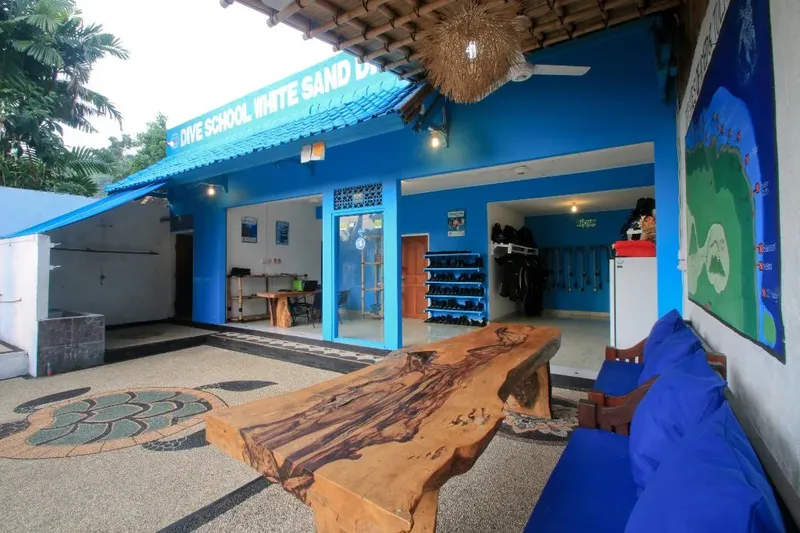 Façade d'une école de plongée bleue avec équipement et mobilier extérieur