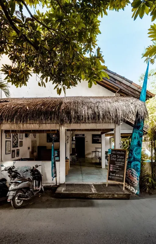 Façade d'un centre de plongée avec équipement et scooter garé
