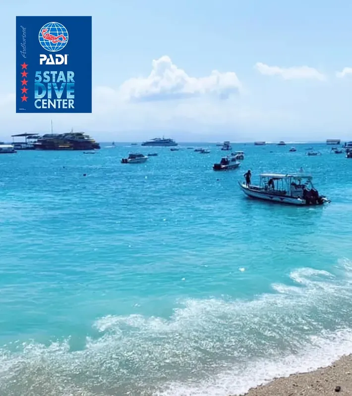 Vue mer avec bateaux, plage et logo PADI 5 étoiles