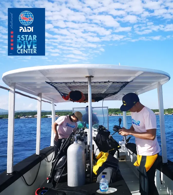 Deux plongeurs équipés sur un bateau, préparation pour une sortie