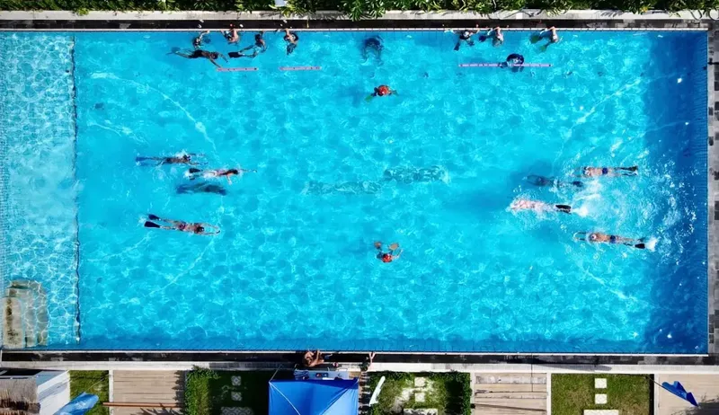 Vue aérienne d'un groupe de personnes dans une piscine bleu clair