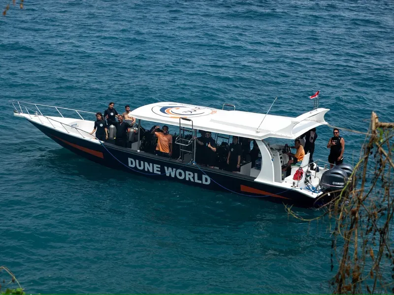 Bateau de plongée rempli de personnes sur une mer bleue calme