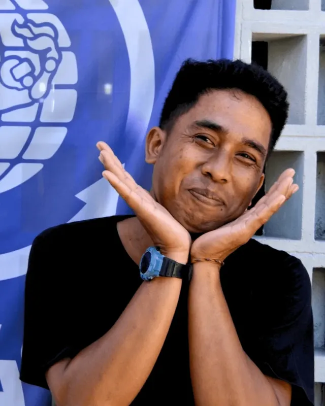 Portrait d'un homme souriant avec les mains près du visage