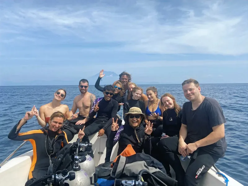 Groupe de plongeurs souriants à bord d'un bateau en mer