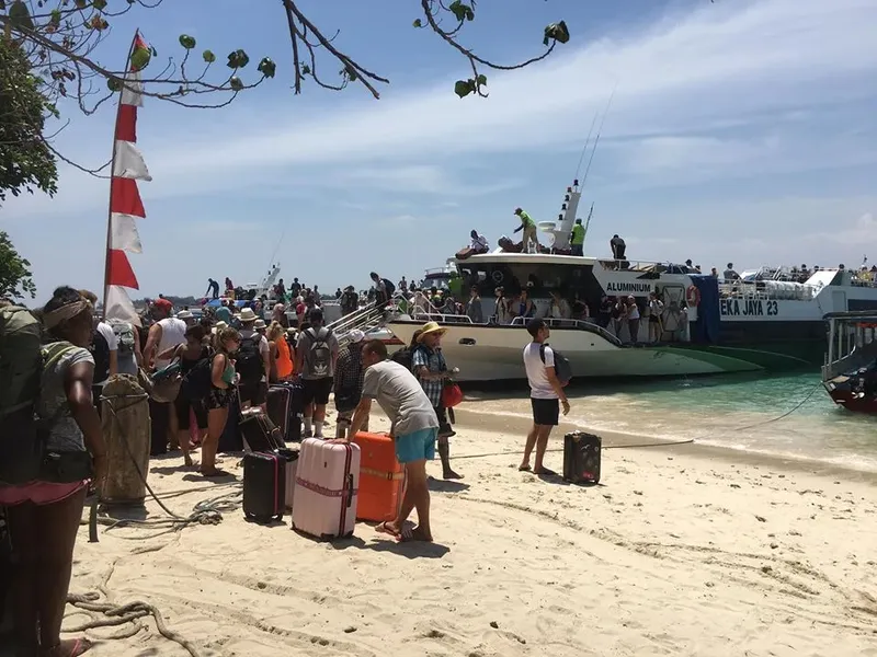 Plage ensoleillée avec des personnes et des bateaux préparant une excursion