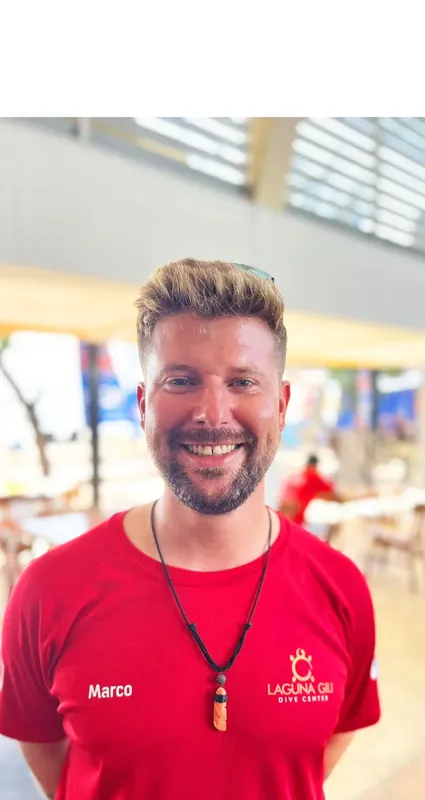 Portrait d'un homme souriant avec un t-shirt rouge et un collier