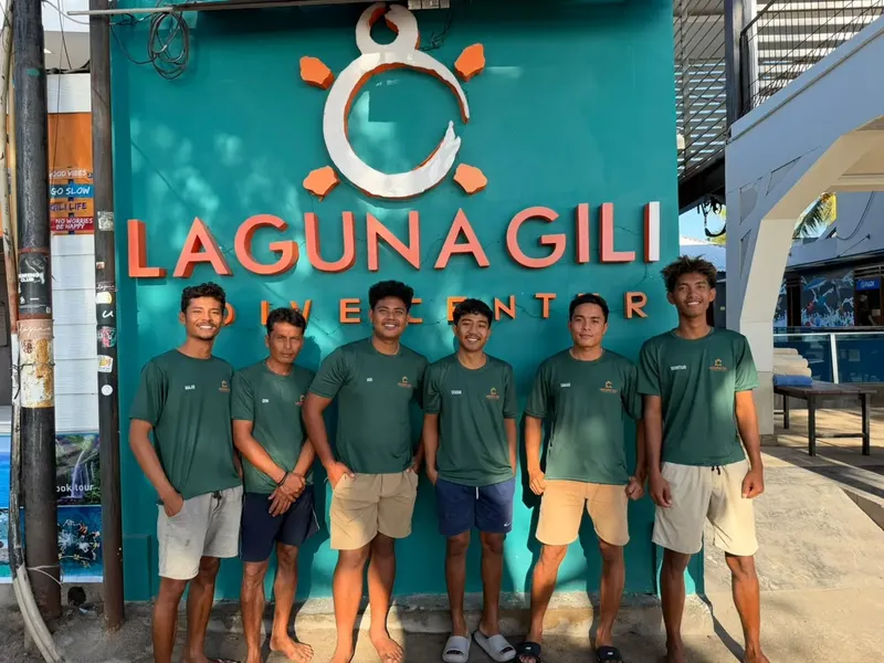 Groupe de personnes souriantes devant une enseigne colorée de centre