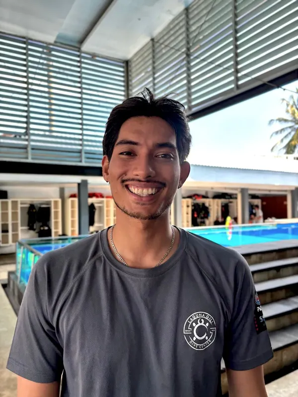 Portrait d'un homme souriant devant un centre de plongée