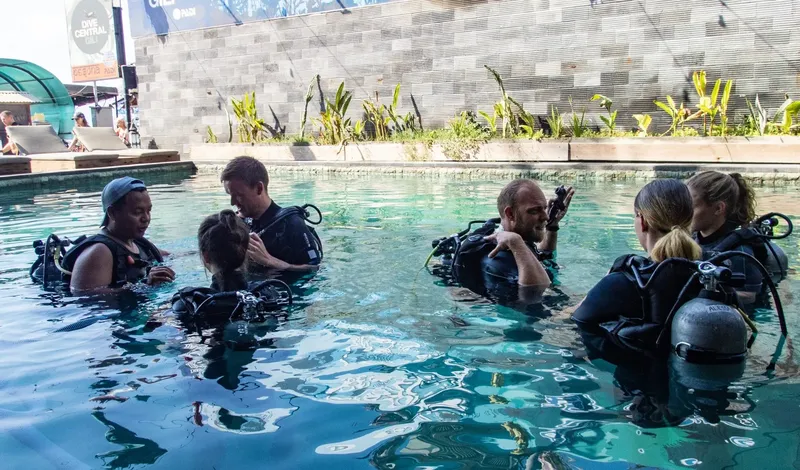 Groupe de plongeurs en formation dans une piscine avec équipement complet