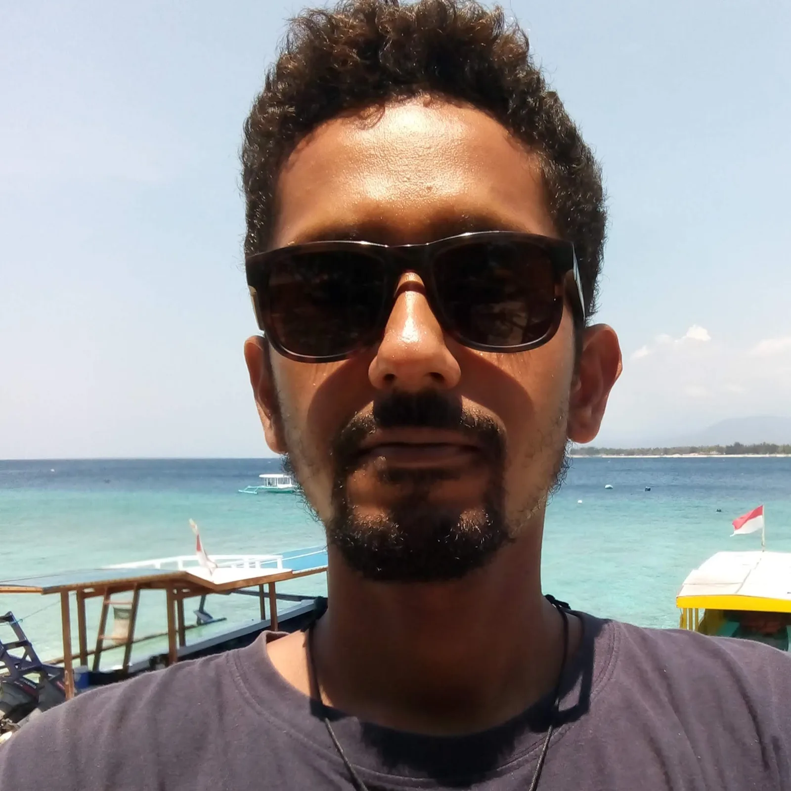 Portrait d'un homme avec des lunettes de soleil devant la mer